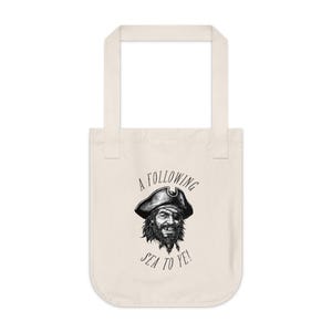 May include: A white tote bag with a black and white illustration of a pirate with the text "A Following Sea To Ye!"