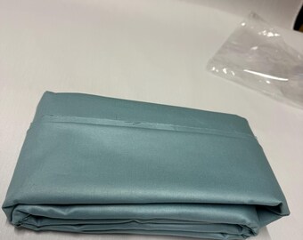 May include: A folded, teal-colored sheet set. The fabric appears smooth and has a slight sheen. The sheet is neatly folded, showing the edges and the layered folds of the fabric. The overall presentation suggests a clean and organized product.
