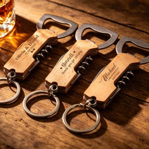 May include: Three engraved wooden bottle openers with keyrings. Each opener features a stainless steel bottle opener and corkscrew. The wooden handles are personalised with names and dates, ideal for a wedding or special occasion.