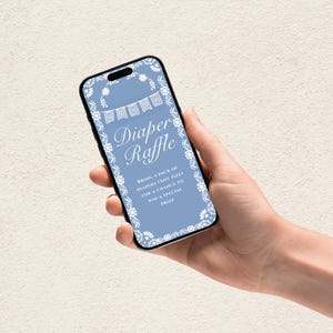 May include: A smartphone screen shows a baby shower invitation for a diaper raffle. The screen has a light blue background with white floral and banner accents. The text reads "Diaper Raffle" and details about the raffle.