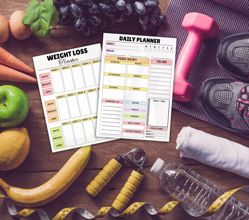 May include: A fitness-themed still life featuring a weight loss tracker and daily planner. A pink dumbbell, running shoes, and a water bottle are also present. Fresh fruit and vegetables, along with hand grips and a measuring tape, complete the scene.