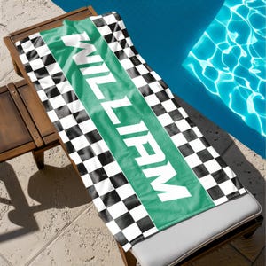 May include: A black and white checkered beach towel with a green stripe that says "WILL FARM" in white letters.