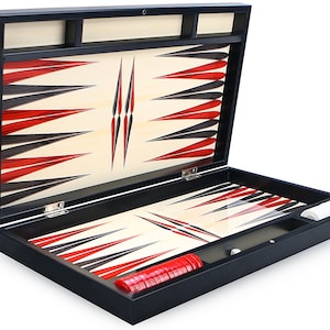 May include: A black wooden backgammon set with a red and black design. The set is open and the playing board is visible. The set includes red playing pieces.