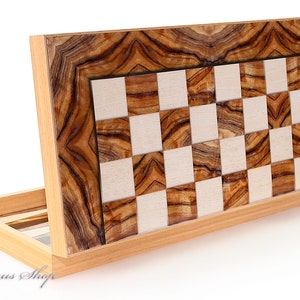 Könnte beinhalten: Ein Schachbrett aus Holz mit einem braunen und weißen Schachbrettmuster. Das Brett ist geschlossen und hat einen Holzrahmen mit einer natürlichen Holzmaserung.
