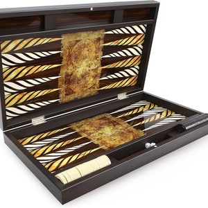 Könnte beinhalten: Ein Backgammon-Set aus Holz mit einem braunen und goldenen Muster. Das Set enthält Würfel, Spielsteine und ein Aufbewahrungsfach.