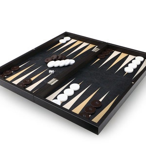 以下が含まれることがあります： 白と金の三角形がついた黒いバックギャモンのボード。ボードが開いており、茶色と白の駒が置かれています。