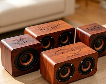 Può includere: Quattro altoparlanti rettangolari in legno con finitura a venature scure e coni neri. Ogni altoparlante presenta incisioni laser personalizzate con disegni botanici, inclusi nomi come Spencer, iniziali e varie date incise.