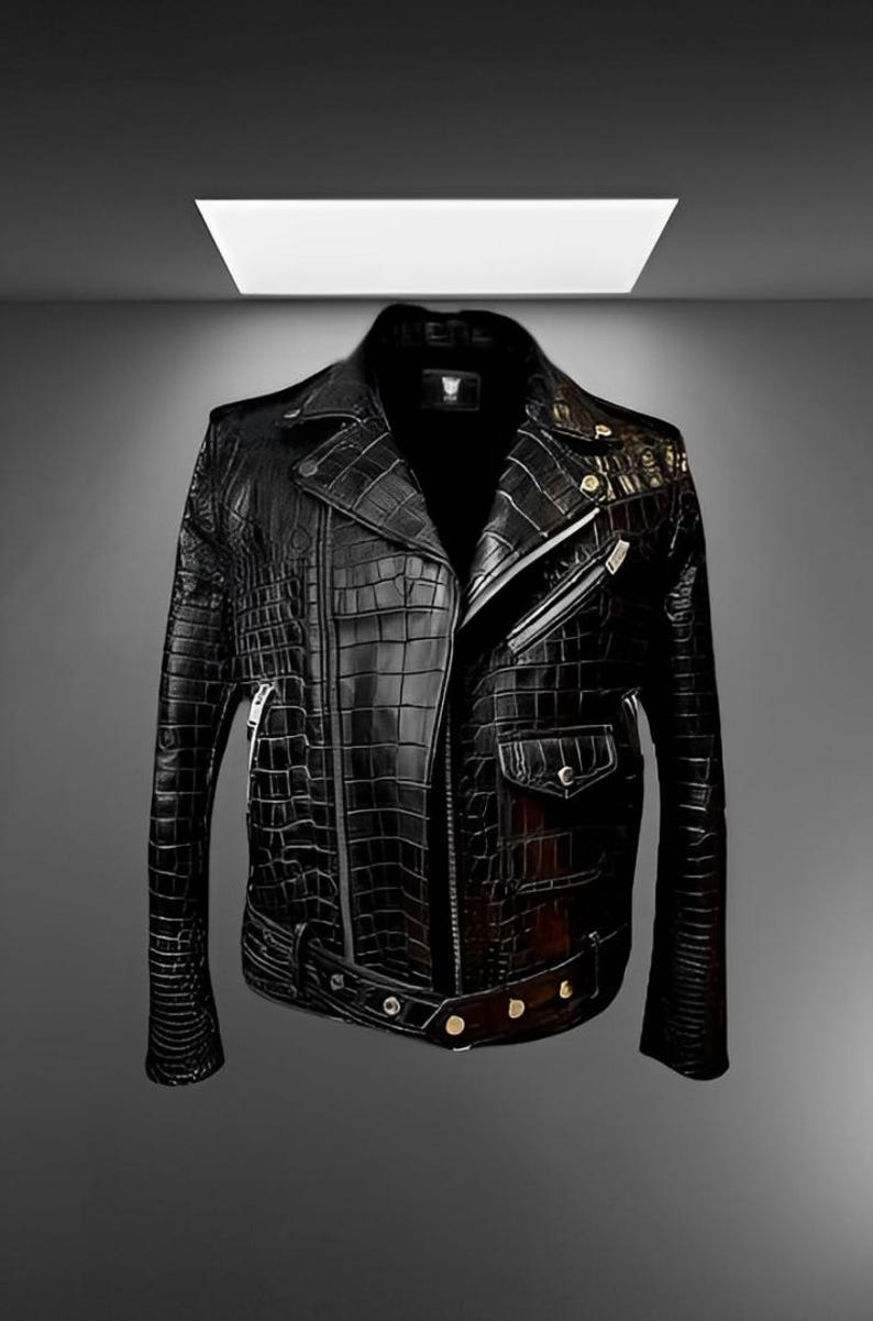May include: Black leather jacket with a crocodile skin texture. The jacket features a classic biker style with a notched collar, asymmetrical zipper, and multiple pockets. Gold-colored hardware accents the design.