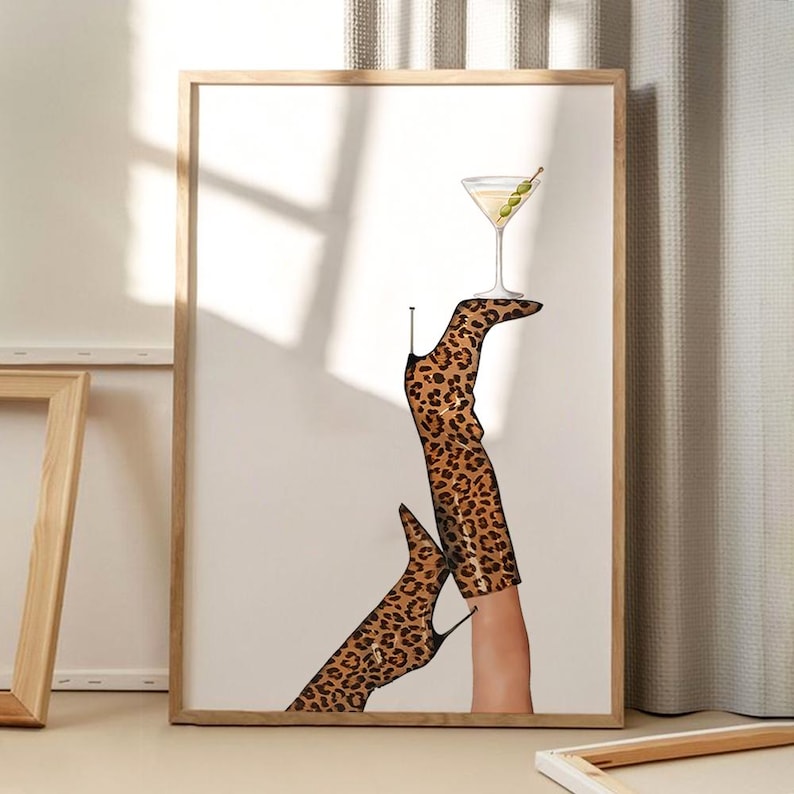 May include: A pair of leopard print boots with a martini glass balanced on top of one boot. The boots are brown and black with a pointed toe.