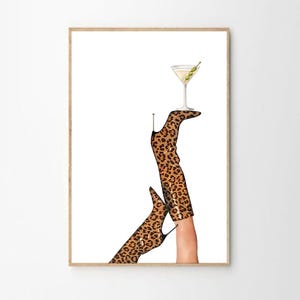 May include: A pair of leopard print boots with high heels, one boot is holding a martini glass with an olive garnish.