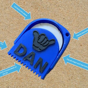 May include: Blue surf wax container with a comb and a scraper. The lid locks into place and has a keychain hole. The container is labeled "DAN".