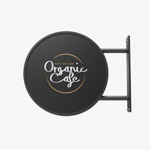 May include: Black round sign with a gold circle and white text that reads "Farm And Cafe Organic Cafe". The sign is attached to a black metal frame.