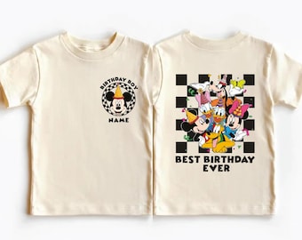 May include: Cream-coloured short-sleeved t-shirt featuring Mickey Mouse with a birthday hat and the text "Birthday Boy" on the front. The back of the shirt displays a group of Disney characters with the text "Best Birthday Ever."