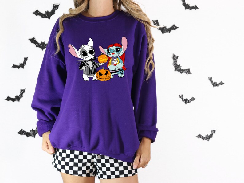 May include: A purple sweatshirt with a Halloween-themed graphic of Jack Skellington and Stitch holding pumpkins. Black bat decorations are on the background. The person is wearing black and white checkered shorts.