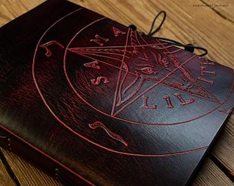 May include: A dark red leather journal with a pentagram and the words "SAMAEL LIIIT" embossed in red.