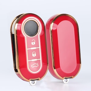 May include: Red and gold car key fob with three buttons and a car icon. The key fob has a gold trim and a red finish.