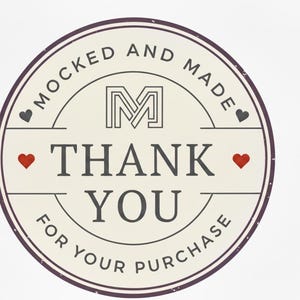 May include: A circular sticker with a cream background and a dark purple border. The text "MOCKED AND MADE" arcs around the top, and "THANK YOU" is centered. Red hearts and a gray heart are included.
