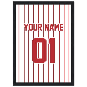 Op de afbeelding: Ingelijste print met een witte achtergrond en verticale rode strepen. Het ontwerp bevat de tekst "YOUR NAME" in rode blokletters boven het nummer "01" in een vetgedrukte rode letter. De print is ingesloten in een zwart frame.