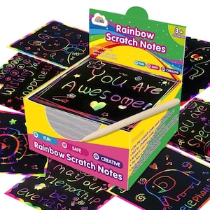 May include: A box of rainbow scratch notes with a wooden stylus. The box is yellow with a rainbow border and the words "Rainbow Scratch Notes" in black text. The notes are black with rainbow colors underneath the scratch-off layer. The notes have various messages, including "You Are Awesome!" and "May our Friendship be everlasting".