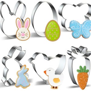 May include: A collection of stainless steel cookie cutters in Easter shapes, including a bunny, egg, butterfly, chick, and carrot. Each cutter has a corresponding decorated cookie in bright colors, such as blue, green, and orange.