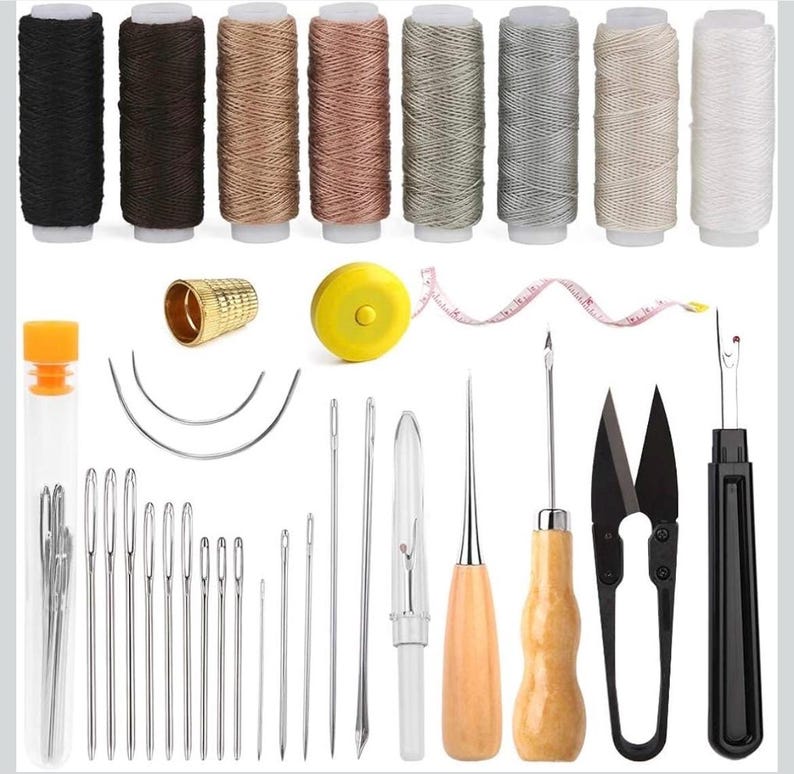 May include: A comprehensive sewing kit featuring a range of tools and materials. The image displays spools of thread in diverse shades, needles, a thimble, a tape measure, scissors, and a seam ripper, all arranged on a white backdrop.