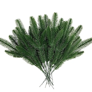 May include: A bunch of artificial green pine sprigs with wire stems. The sprigs are arranged in a fan shape.