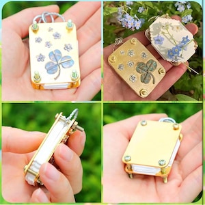 以下が含まれることがあります： 金色のクローバー型の小さなチャームのクローズアップ画像が4つあります。各チャームは、白い中心のクローバー、緑色の中心のクローバー、白い中心と花柄のクローバー、無地の金色のクローバーなど、異なるデザインになっています。