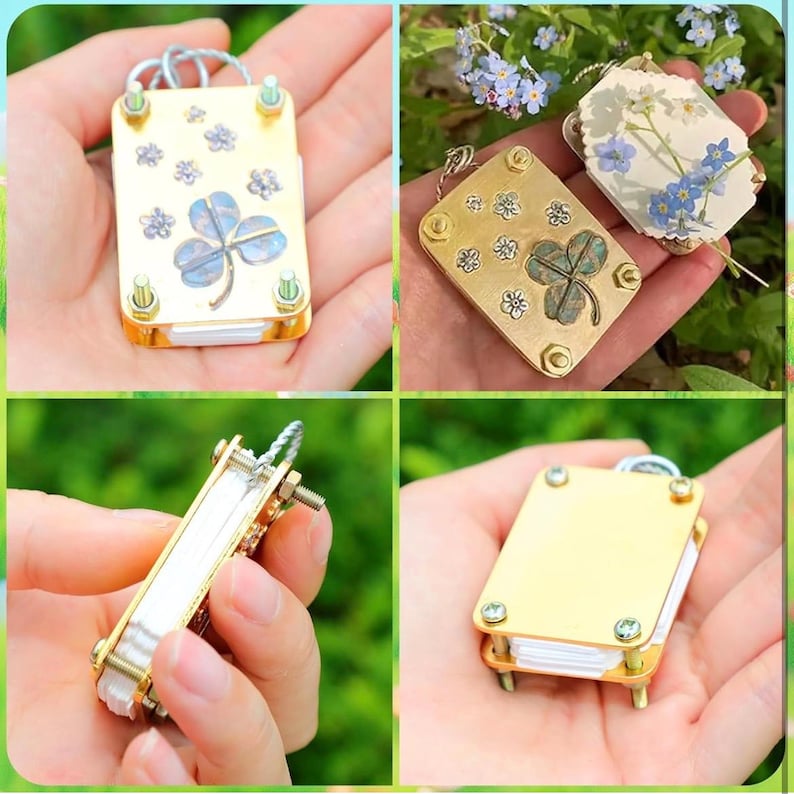 以下が含まれることがあります： 金色のクローバー型の小さなチャームのクローズアップ画像が4つあります。各チャームは、白い中心のクローバー、緑色の中心のクローバー、白い中心と花柄のクローバー、無地の金色のクローバーなど、異なるデザインになっています。