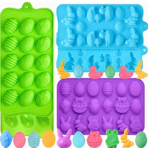 May include: A collection of colorful silicone molds for making Easter-themed treats. The molds are green, blue, and purple, featuring egg, bunny, and duck shapes. The image also shows several finished treats in various colors.