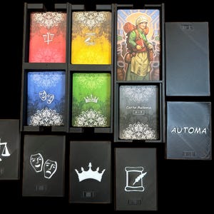 Pu&ograve; includere: Un gioco di carte in bianco e nero con una variet&agrave; di simboli, tra cui una bilancia, una corona, un rotolo e una maschera. Le carte sono disposte in una griglia e sono etichettate con la parola "AUTOMA".
