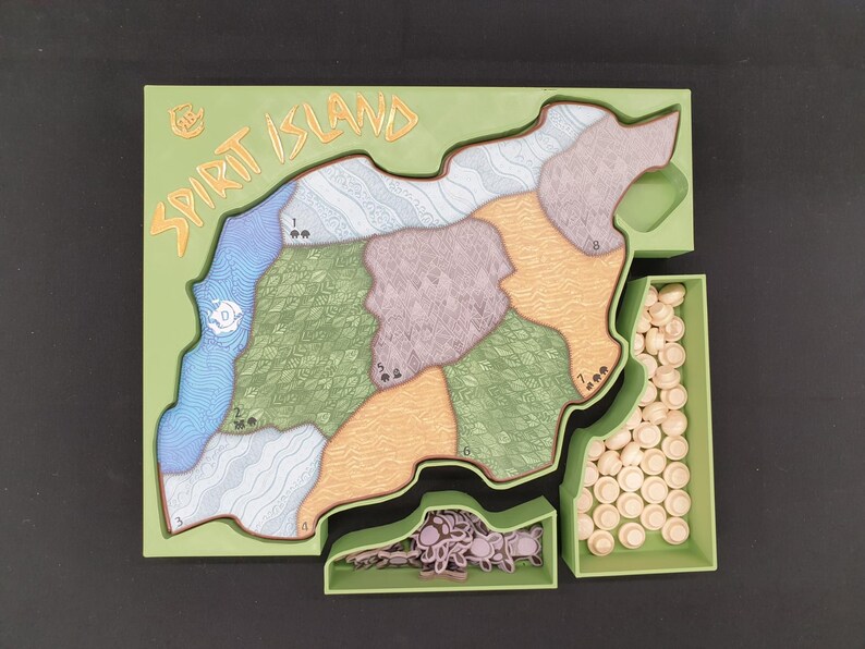 May include: A board game titled "Spirit Island" with a green frame. The game board features a map divided into numbered regions with various colors and textures. Includes small, beige game pieces and tokens in green trays.