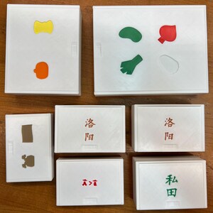 May include: Eight white square boxes with different colored shapes and Japanese characters. The shapes include a yellow bow tie, an orange pumpkin, a brown rectangle, a green bean, a green leaf, a red tomato, and a white circle. The Japanese characters are "發問" and "本田".