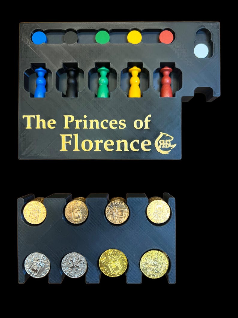 May include: A black plastic game organizer with the title "The Princes of Florence" in gold lettering. The organizer has slots for game pieces and coins. The game pieces are colored blue, black, green, yellow, and red. The coins are gold and silver.