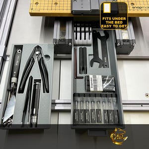 Puede incluir: Dos cajones grises con varias herramientas y suministros. El cajón de la izquierda contiene un par de alicates, un destornillador y una llave. El cajón de la derecha contiene un juego de herramientas pequeñas, una llave y un juego de tornillos pequeños. El texto en el cajón dice "Fits under the bed, easy to get".