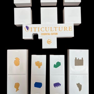 May include: White game pieces with various colored symbols, including a purple grape, a gold building, a blue building, a green building, a purple building, and a gold building. The game pieces are arranged in a U-shape with the words "VITICULTURE ESSENTIAL EDITION" in gold letters on a white piece in the center.
