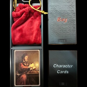 May include: A black wooden box with two compartments. The top compartment holds a red velvet bag with a gold drawstring. The bottom compartment holds a stack of cards with the text "Character Cards". The box also has a separate compartment labeled "Bag".