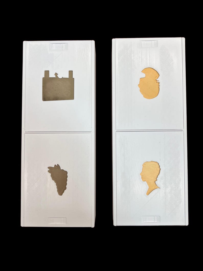 May include: Two white boxes with different images on each side. The top left box has a brown silhouette of a car battery. The bottom left box has a brown silhouette of a bunch of grapes. The top right box has a gold silhouette of a person's head. The bottom right box has a gold silhouette of a person's head in profile.