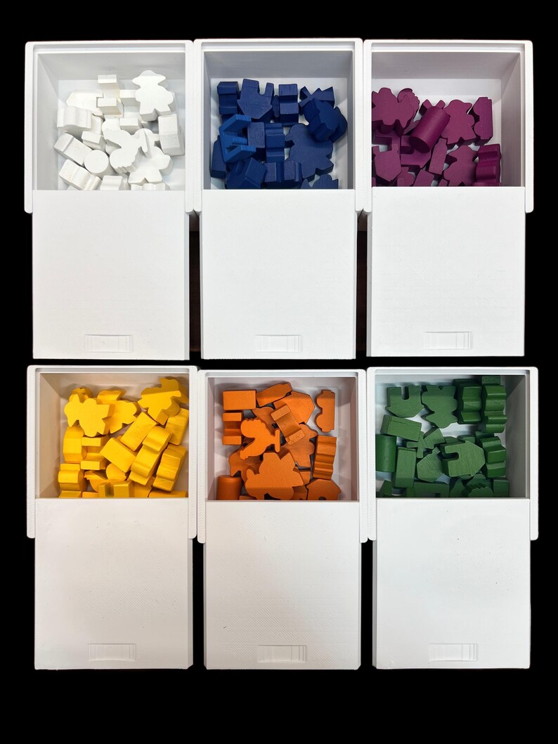 Puede incluir: Seis cajas blancas con tapas, cada una contiene piezas de juego de madera de un color diferente. Las cajas est&aacute;n dispuestas en dos filas de tres. Los colores de las piezas son blanco, azul, morado, amarillo, naranja y verde.