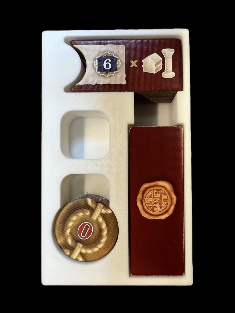 May include: A white plastic tray with a red and white card with a number 6 and a building icon, a red card with a wax seal, and a brown token with a rope design and a number 0.