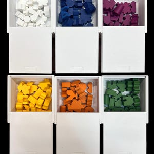 May include: Six white boxes with lids, each containing a different color of small wooden pieces. The colors are white, blue, purple, yellow, orange, and green.