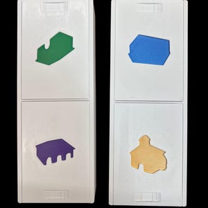 Puede incluir: Dos cajas blancas con diferentes formas de colores en cada lado. La caja superior izquierda tiene una forma de casa verde, la caja superior derecha tiene una forma de casa azul, la caja inferior izquierda tiene una forma de casa morada y la caja inferior derecha tiene una forma de casa amarilla.