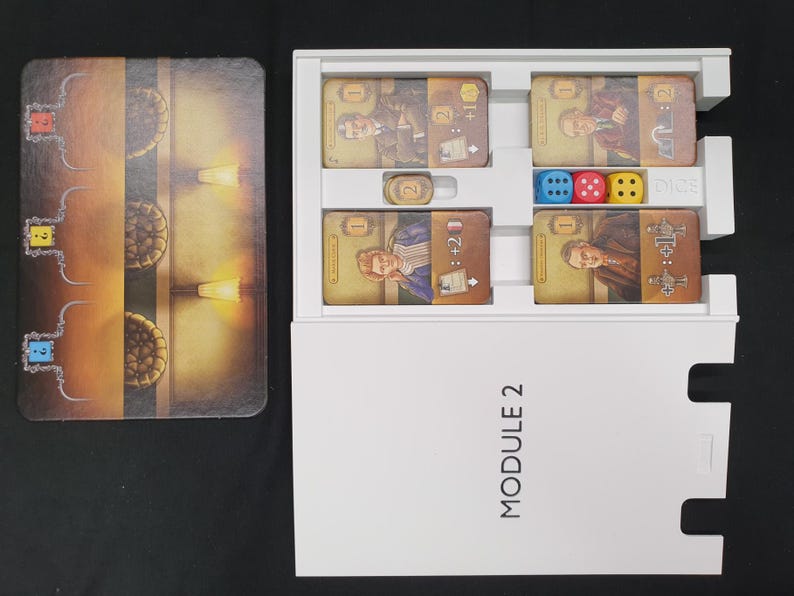 May include: A board game set with cards, dice, and a game board. The cards feature illustrations of people and symbols. The dice are blue, red, and yellow. The game board has a brown and gold design with a maze-like pattern.