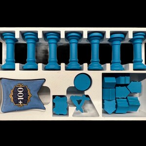 May include: A white foam insert with blue plastic game pieces. The insert has eight slots for the blue columns, a space for a blue banner with the text " +100", and a space for a set of blue plastic shapes.