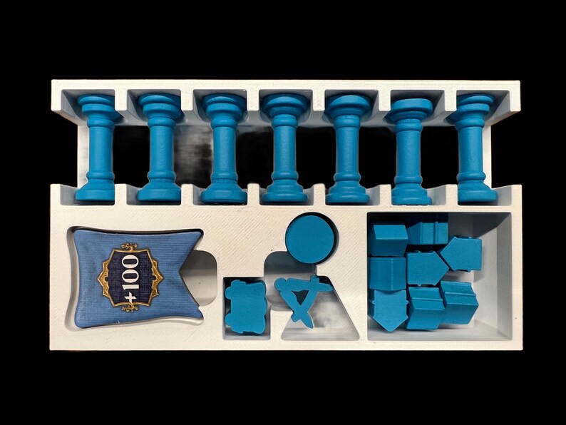 May include: A white foam insert with blue plastic game pieces. The insert has eight slots for the blue columns, a space for a blue banner with the text " +100", and a space for a set of blue plastic shapes.