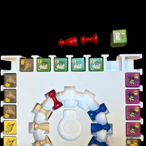 May include: A white game board with a circular track in the center. There are red, blue, and wooden game pieces on the track. There are also small square game tiles with images of sheep, grapes, and other items. The tiles are arranged in rows on the board.