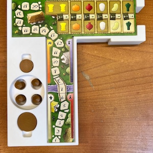 May include: A white plastic game board with a green and brown game track, a white plastic scoring area with numbers 1-20, and a white plastic scoring area with numbers 30-60. The game board is designed for a board game.