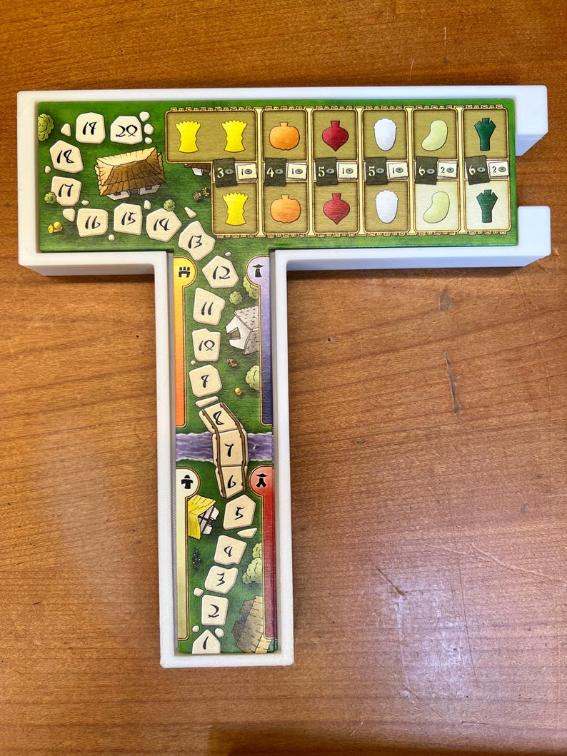 May include: A white plastic game board with a green and brown game piece track. The track has numbers 1 through 20. The board has a T-shape with a separate section at the top with a row of 6 different colored game pieces. The game pieces are yellow, orange, red, white, green, and blue.