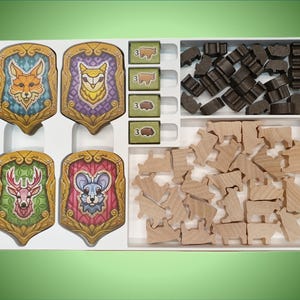 May include: A white wooden box with four colorful animal shields and two compartments filled with wooden animal and house shaped pieces.