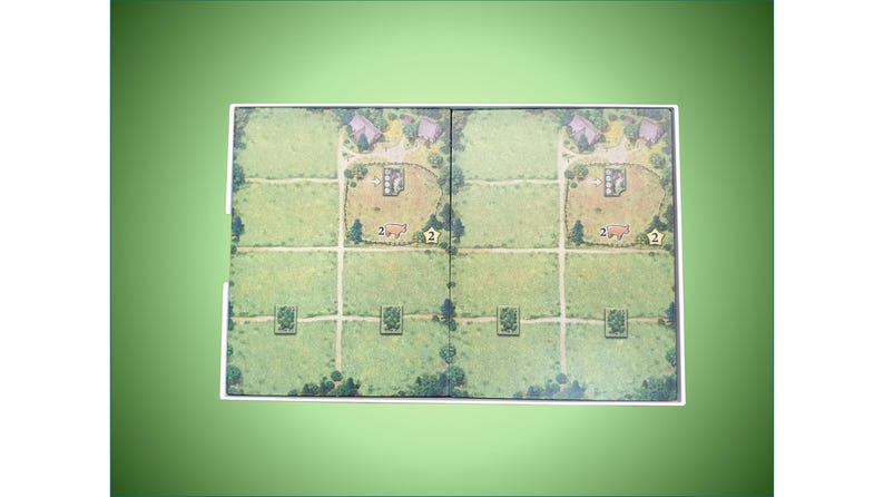 May include: A game board with two identical sides, each featuring a green field with a small village, a barn, and a field with a number "2" on it. The board is divided into squares with paths.