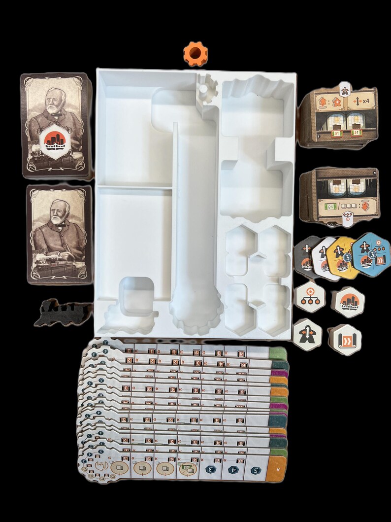 May include: A white organizer tray with compartments for storing game pieces, cards, and tokens. The tray is filled with various game components, including wooden tokens, cards with illustrations of men, and a small gear-shaped piece.